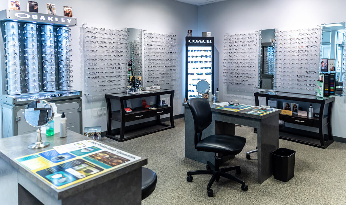 Wide shot of optical department, featuring walls of glasses on display.